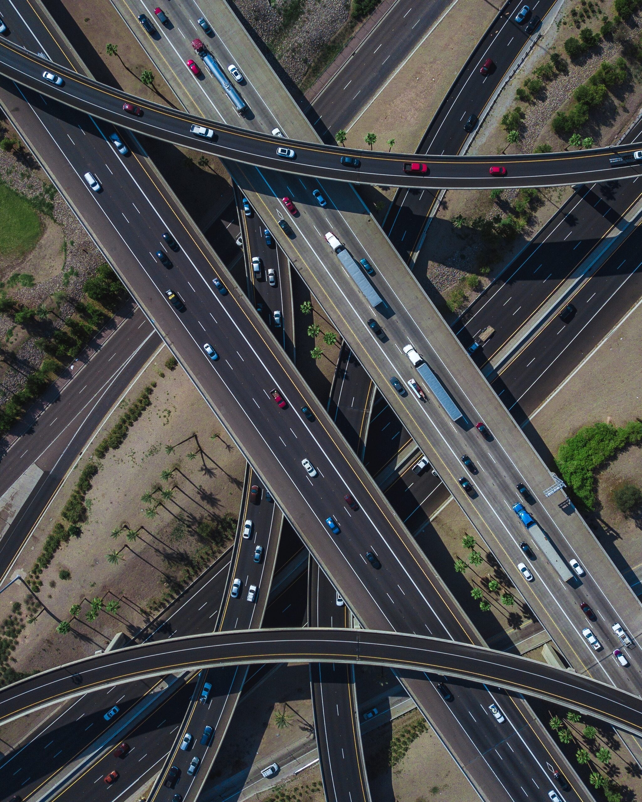 overhead drone shot of a busy highway intersection full of traffic during daytime